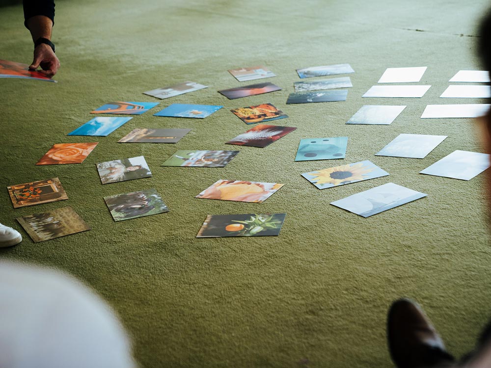 verschiedene Postkarten mit Stimmungsbildern auf einem grünen Teppichboden