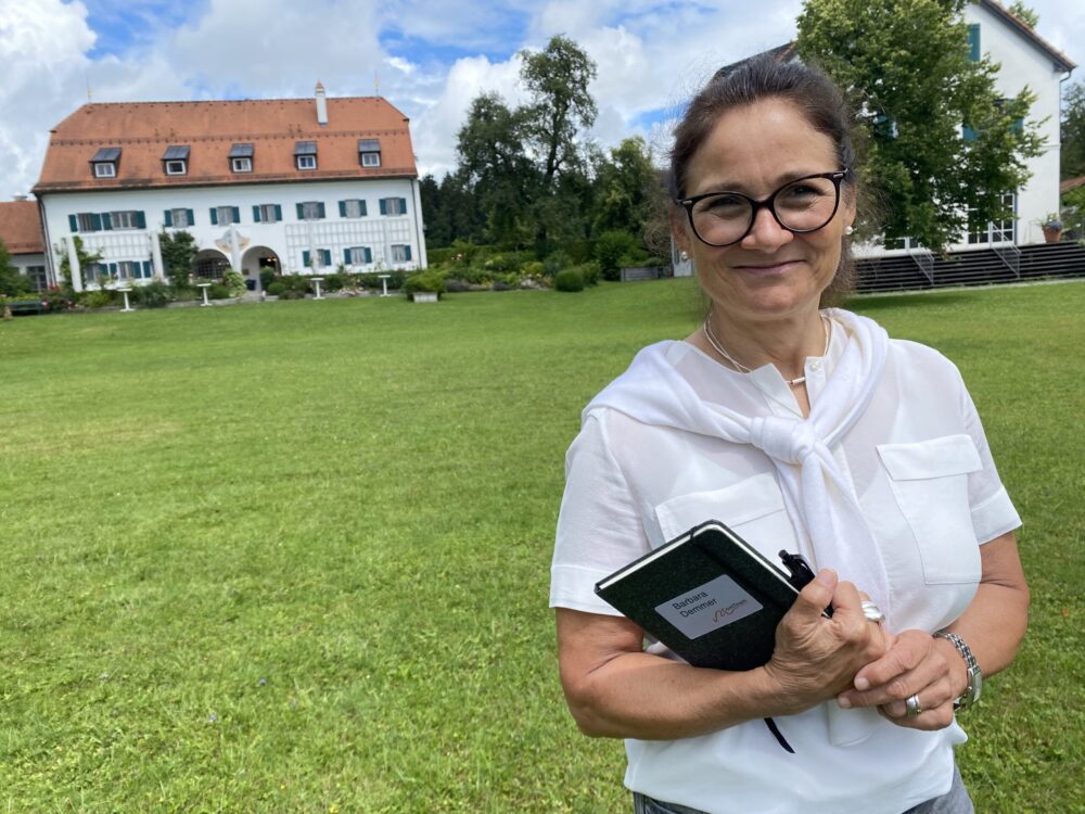 Teilnehmerin der Business-Coaching-Ausbildung, Barbara Demmer, vor dem Seminarhotel Aiterbach am Chiemsee