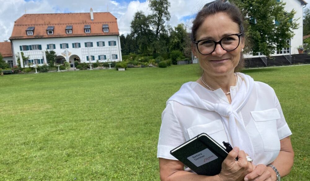 Teilnehmerin der Business-Coaching-Ausbildung, Barbara Demmer, vor dem Seminarhotel Aiterbach am Chiemsee